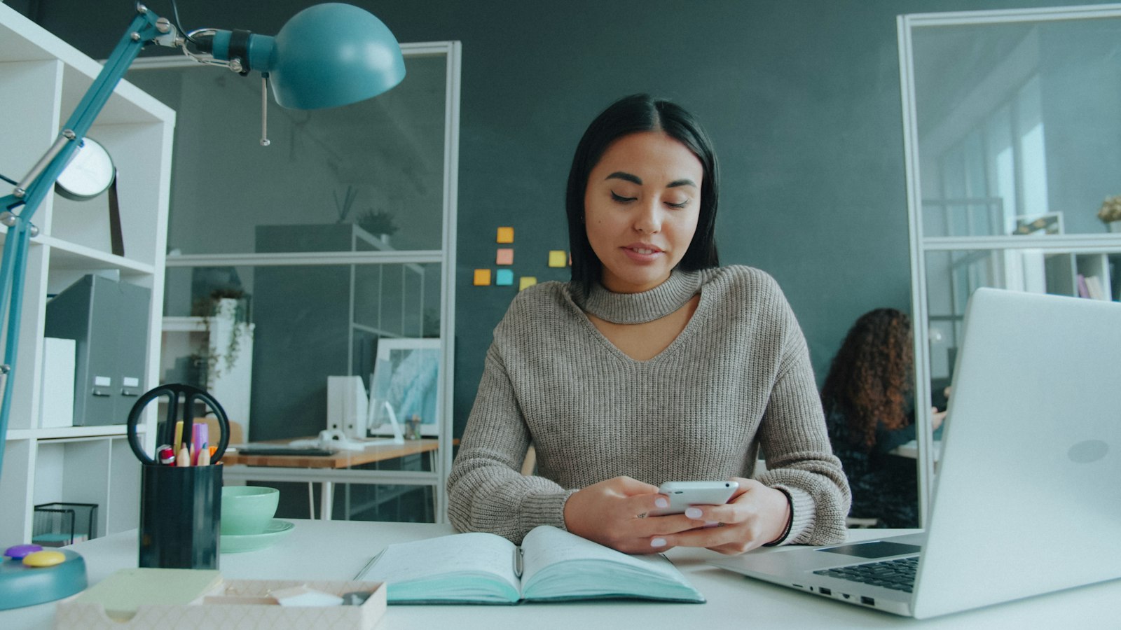An employee using her phone at her desk
